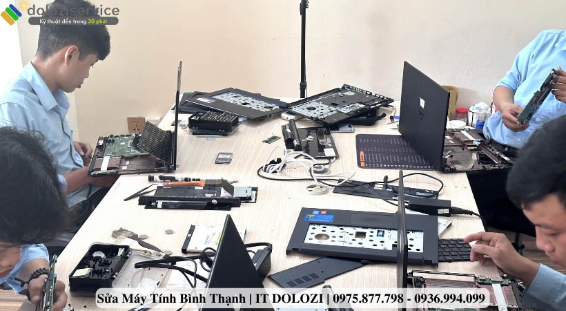 Các kỹ thuật viên đang sửa máy tính, laptop cho khách hàng