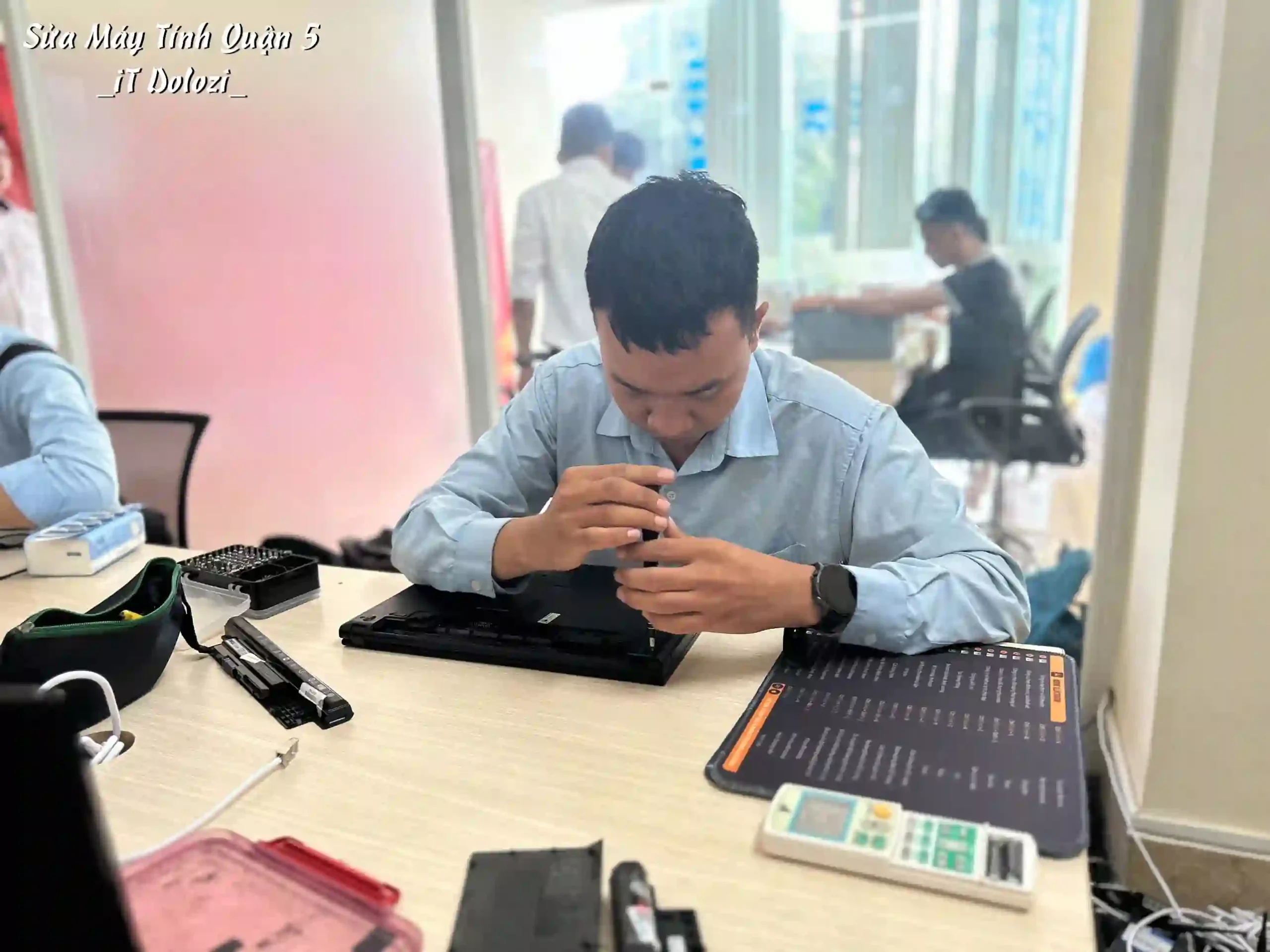 Kỹ thuật viên đang vặn ốc mở laptop, máy tính ra để kiểm tra lổi