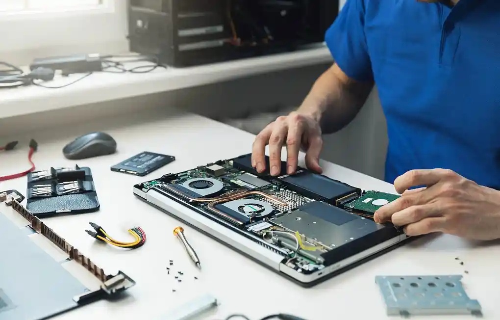Kỹ thuật viên đang lắp ổ cứng vào laptop cho khách hàng