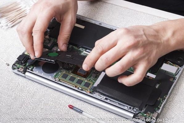 Kỹ thuật viên đang lắp lại bộ phận của laptop